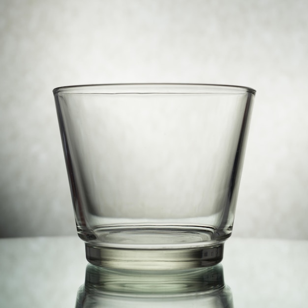 Photo un tir vertical d'un verre vide sur un fond gris