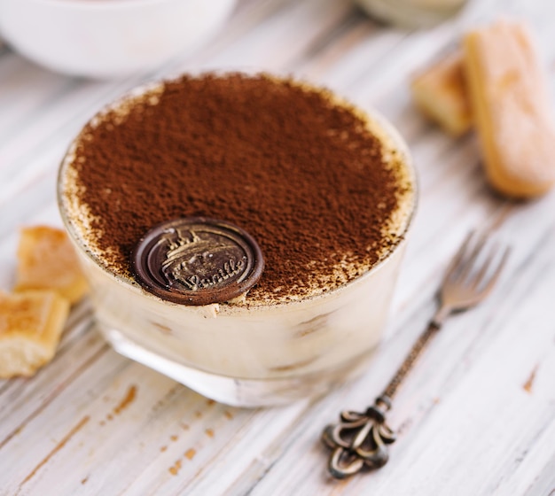 Tiramisu dans le verre sur le bois