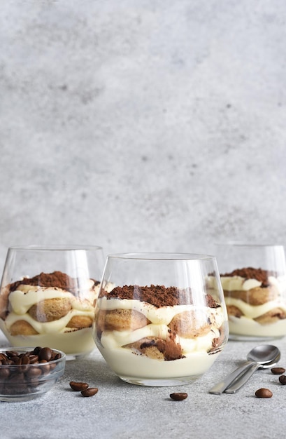 Tiramisu dessert italien dans un verrexTiramisu classique avec café sur fond de béton