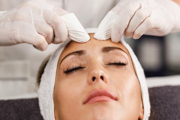 Tiré d'une belle jeune femme sur un soin du visage au salon de beauté.