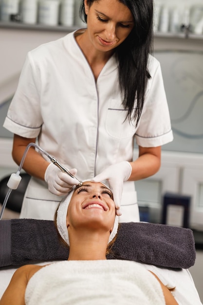 Tiré d'une belle jeune femme sur un traitement facial de microdermabrasion au salon de beauté.