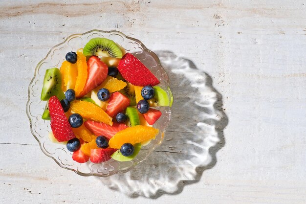 Tiré d'en haut d'un bol en verre transparent rempli de fruits frais sains tranchés