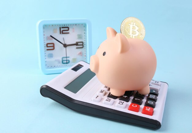 Tirelire avec calculatrice bitcoin et horloge sur fond bleu