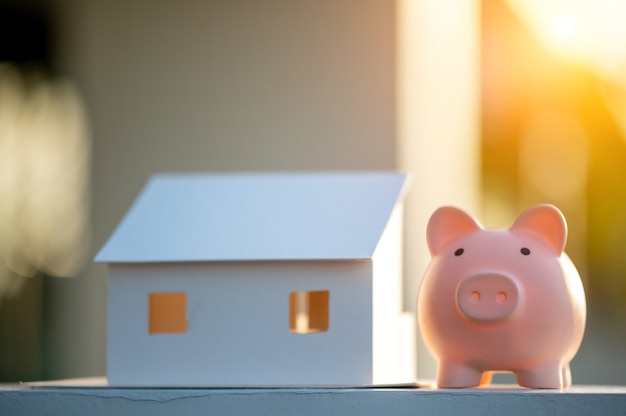 Tirelire et modèle de maison, concept Économiser de l'argent pour la maison et l'immobilier.