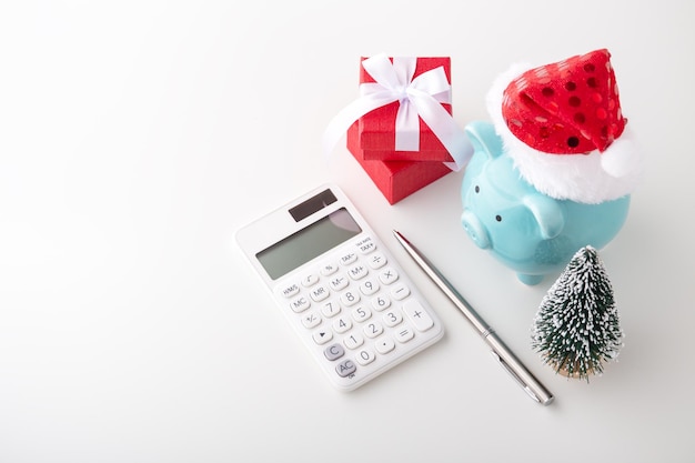 Tirelire portant un chapeau de Noël avec calculatrice et stylo