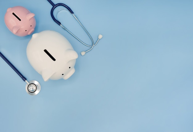 Tirelire avec stéthoscope sur bleu Bilan financier des soins de santé économiser le concept d'assurance médicale