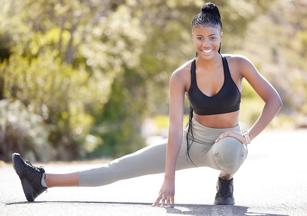 Étirement des jambes portrait de remise en forme et femme noire s'entraînant pour le marathon dans la nature en cours d'exécution pour l'exercice cardio et heureux avec l'entraînement dans le parc pendant l'été