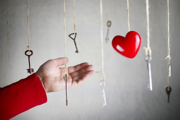 Étirement de la main pour l'une des nombreuses anciennes clés vintage suspendues à des fils