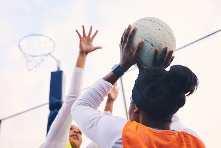 Photo tireur de but de netball et remise en forme d'un groupe d'athlètes féminines sur un terrain de sport extérieur viser le jeu sportif et le défi de match d'une personne noire avec un ballon faisant de l'exercice et s'entraînant dans une compétition