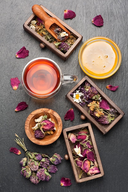 Tisane aux herbes et fleurs séchées au miel sur fond de pierre noire