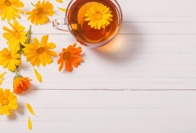 Tisane de calendula (souci) sur table en bois blanc