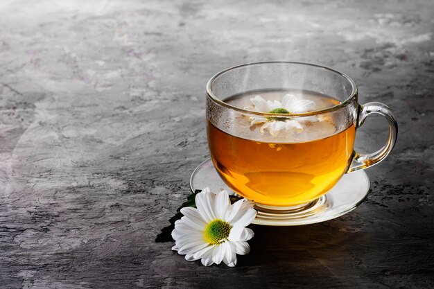 Tisane à la camomille sur fond sombre.