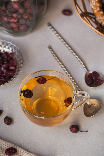 Tisane chaude avec un dogrose dans une tasse en verre. Concept d'alimentation saine.