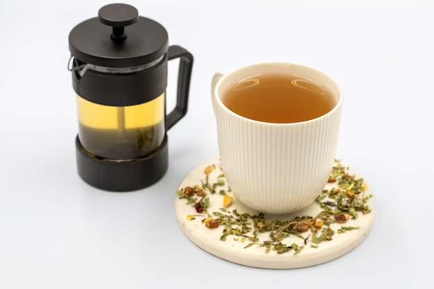 Tisane de détente sur fond blanc Tisane préparée avec des feuilles de mélisse fleur de jasmin zeste de pomme citron orange et particules d'hibiscus