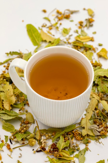 Photo tisane d'hiver isolée sur fond blanc thé de tilleul tisane immunostimulante thé médicinal préparé à partir de feuilles de tilleul particules de clou de girofle et camomille