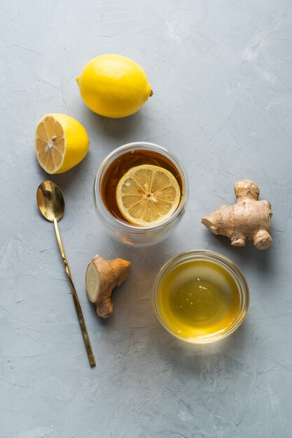 Tisane de vie saine thé au miel de citron avec racine de gingembre sur une surface grise