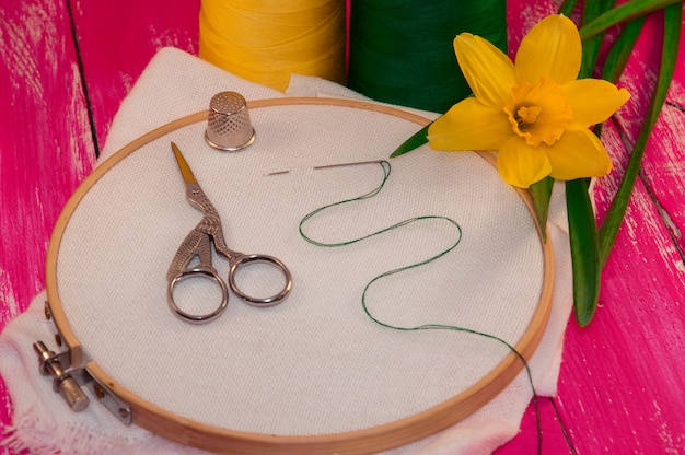 Tissu blanc dans le cadre de broderie en bois pour travaux d&#39;aiguille sur fond en bois rose