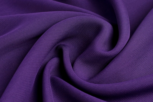 Le tissu en coton naturel de violet est empilé de vagues.