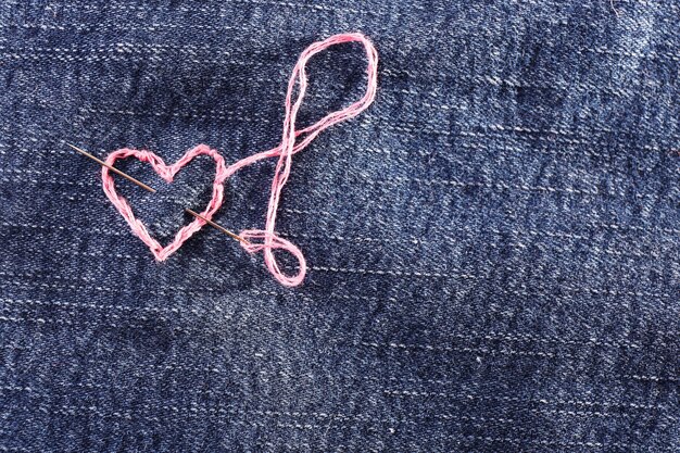 Tissu jeans avec un coeur rose brodé dessus, gros plan