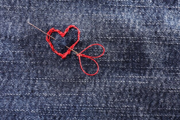 Tissu jeans avec un coeur rouge brodé dessus, gros plan