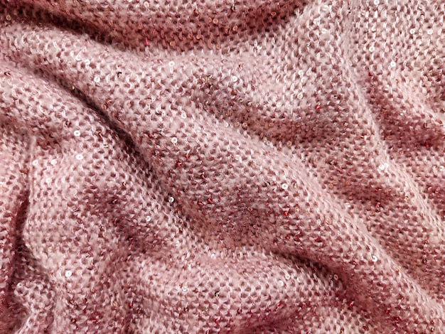 tissu de laine épais et moelleux de couleur rose douce avec de petites paillettes cousues dedans texture très chaude et confortable et textiles roulés et pliés en plis