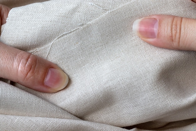 Tissu en lin naturel entre les mains des femmes.