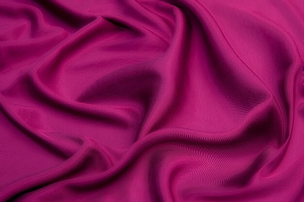 Tissu luxueux en viscose ou soie rouge. Contexte et motif.