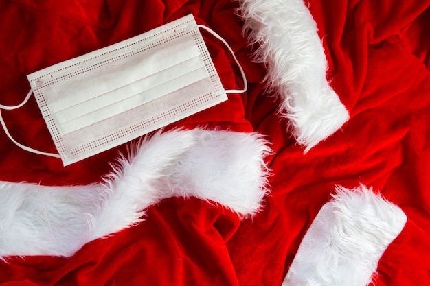 Tissu Santa Costume avec texture de fond de masque de sécurité blanc, concept de Noël et concept Covid-19 2020, gros plan