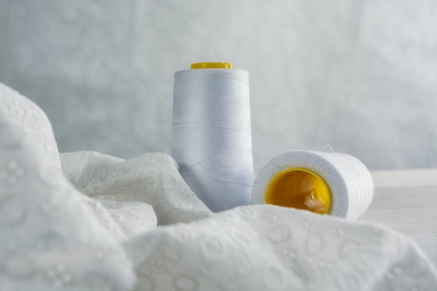 Tissu satiné léger avec des fils sur un fond en bois avec des perles