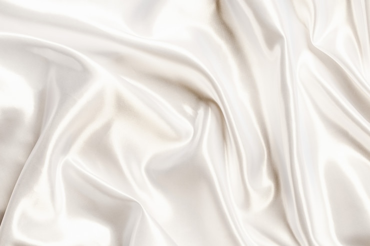 Photo tissu soyeux en satin blanc abstrait pour le fond, drapé en tissu avec plis ondulés. avec des vagues douces, ondulant dans le vent.