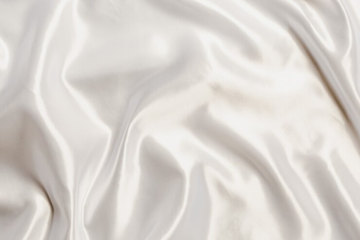 Photo tissu soyeux en satin blanc abstrait pour le fond, drapé en tissu avec plis ondulés. avec des vagues douces, ondulant dans le vent.