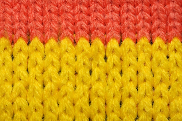 Tissu tricoté synthétique jaune et rouge se bouchent. Texture de tissu tricoté. Texture de tissu tricoté à motifs multicolores. Arrière-plan