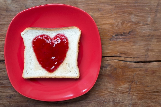 Photo un toast au cœur sur rouge.