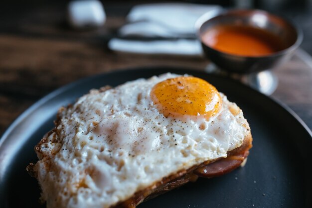 Toast au fromage et saucisse recouvert d'oeuf au plat