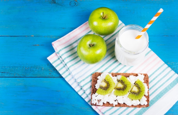 Toast au fromage et tranches de kiwi, pommes vertes juteuses et yaourt