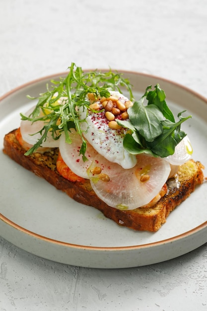 Photo toast aux crevettes grillées et légumes oeuf poché et herbes sur le dessus servi au restaurant