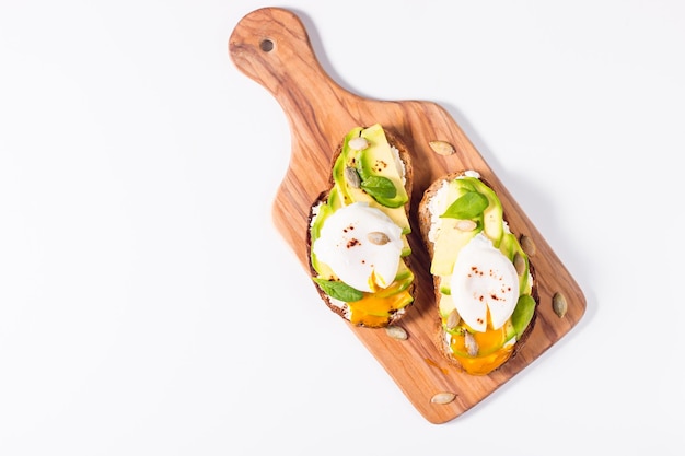 Toast avec avocat, fromage à la crème, pain de seigle et œuf poché.