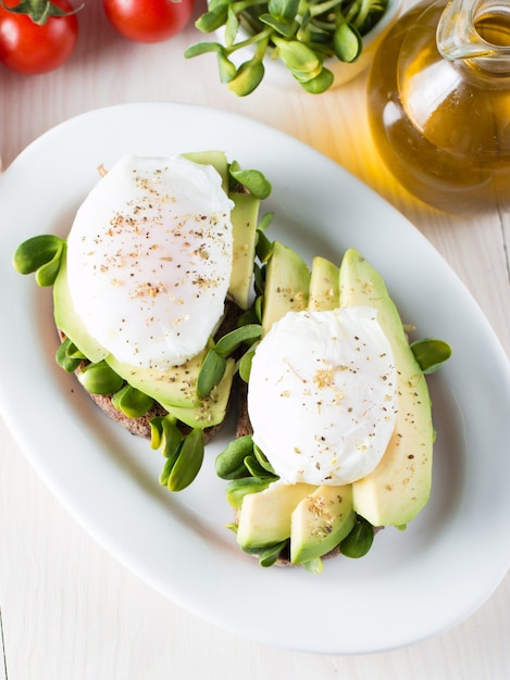 Toast d&#39;avocat à l&#39;oeuf poacehd sur fond en bois.