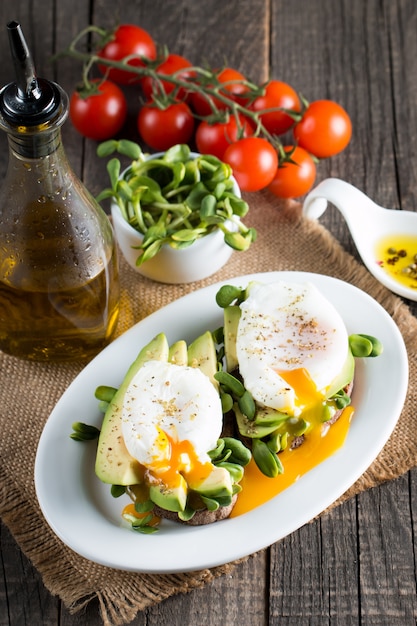 Toast d&#39;avocat à l&#39;oeuf poacehd sur fond en bois.