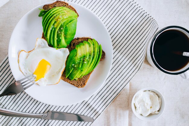 Toast d&#39;avocat sain, café et oeufs sur fond blanc