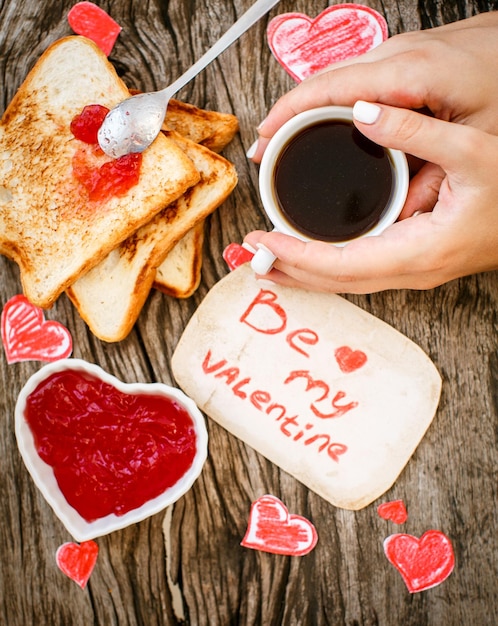 Photo toast avec confiture de fraises be my valentine carte de message blanche avec café dans les mains saint valentin