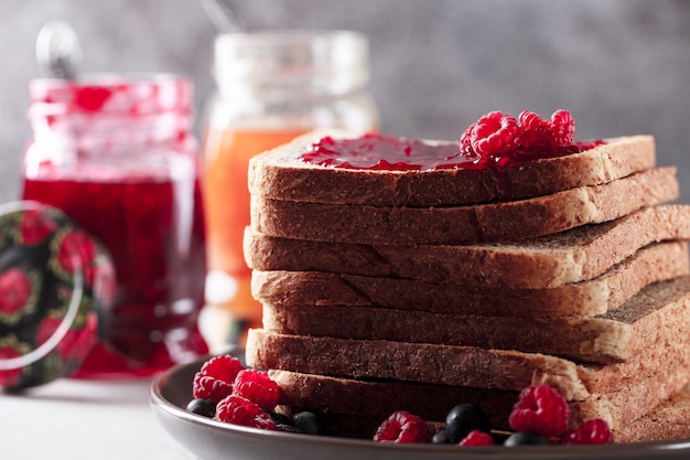 Toast avec de la confiture de framboises sur le dessus