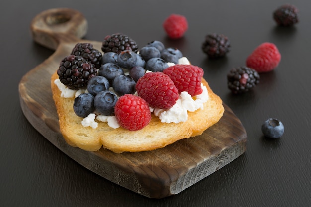 Toast avec du fromage cottage et des baies fraîches.