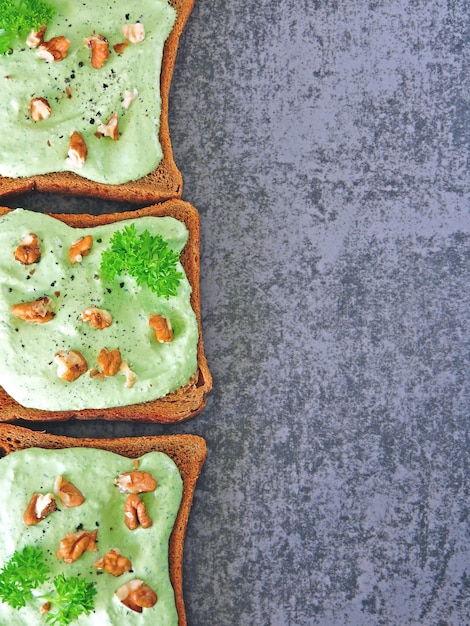 Toast avec du fromage cottage vert et des noix.