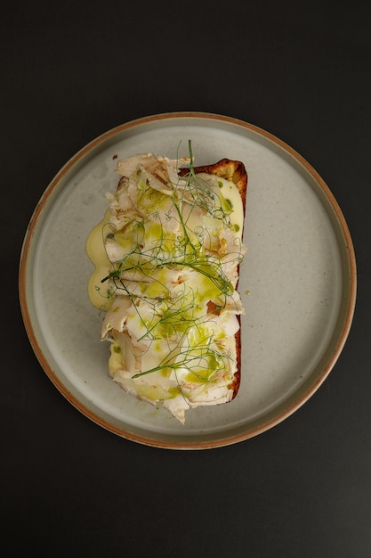 Toast avec filet de poulet servi avec des herbes sur le dessus