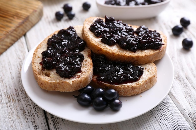 Toast frais avec du beurre et de la confiture sur la table se bouchent