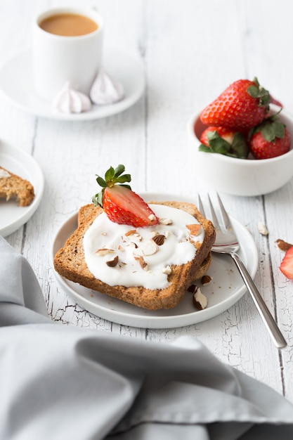 Toast avec fraise aux fruits, menthe et fromage cottage pour le petit déjeuner.