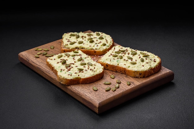 Toast grillé avec pâte d'avocat oeufs fromage à la crème sel épices et herbes