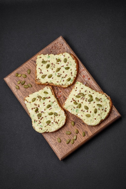 Toast grillé avec pâte d'avocat oeufs fromage à la crème sel épices et herbes