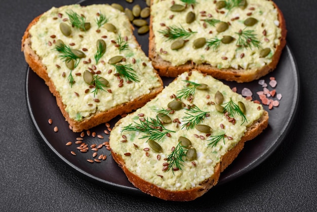 Toast grillé avec pâte d'avocat oeufs fromage à la crème sel épices et herbes